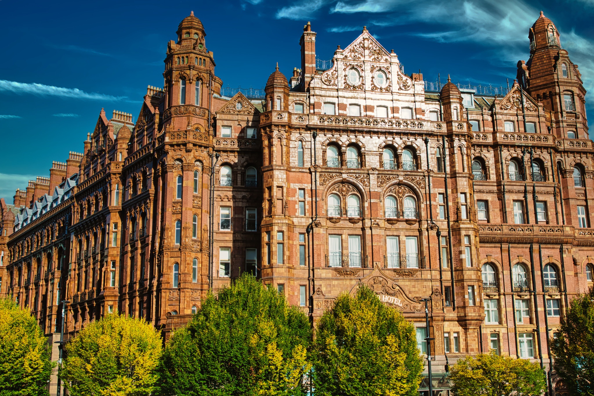 Ornate Brick Building with Trees in Manchester, UK.